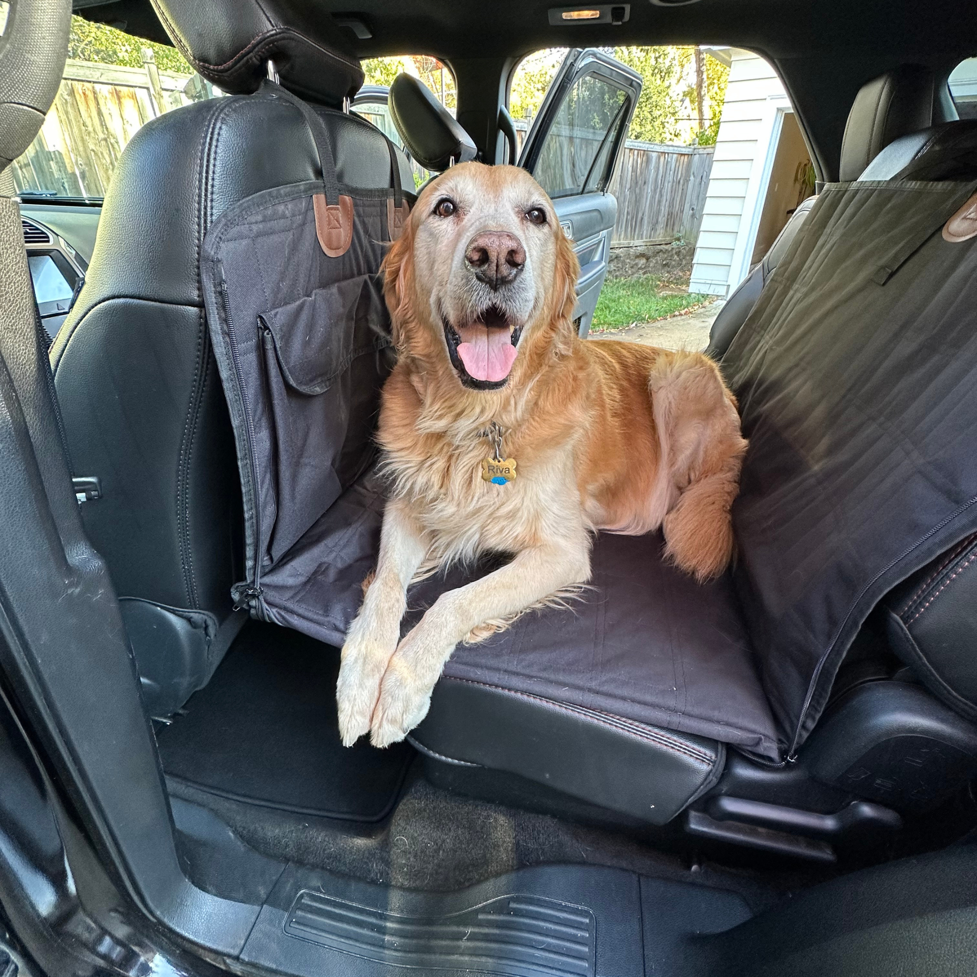 Golden retriever relaxing on calming car bed for dogs installed across the back seat of a vehicle